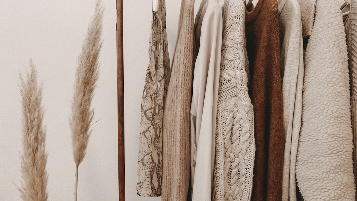 A rack of neutral-toned clothing in cream, camel and brown