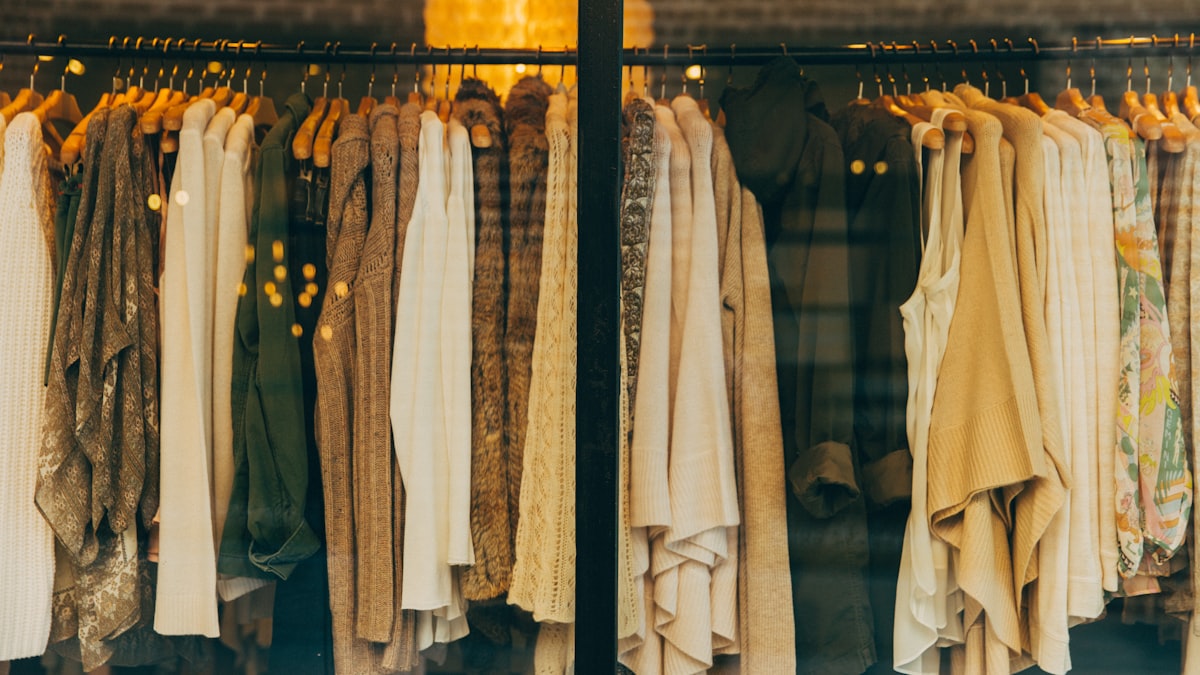 A rack of clothing in a shop window, warm evening light