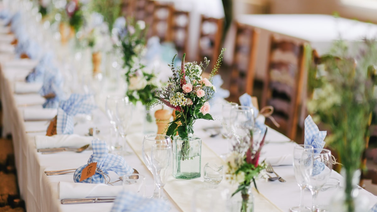 A rustic outdoor wedding table with wildflowers and blue ribbons