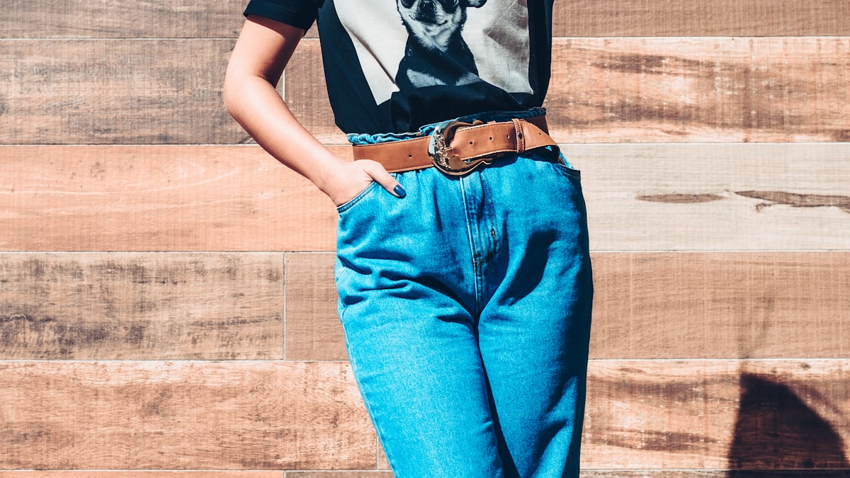 Person wearing high-waisted blue mom jeans with a graphic tee