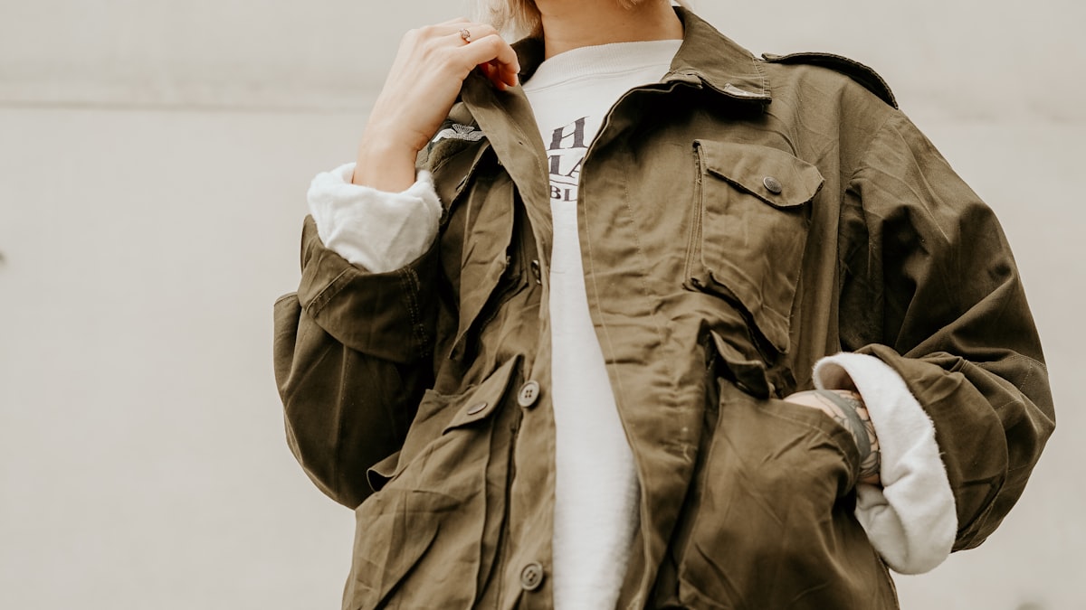 Person wearing an olive fleece-lined utility jacket over a white tee